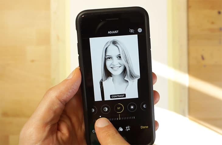 Mano sosteniendo un teléfono que muestra una foto de retrato convertida a blanco y negro